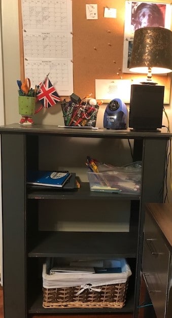 homeschool bookshelf with books, school supplies, and a pencil sharpener